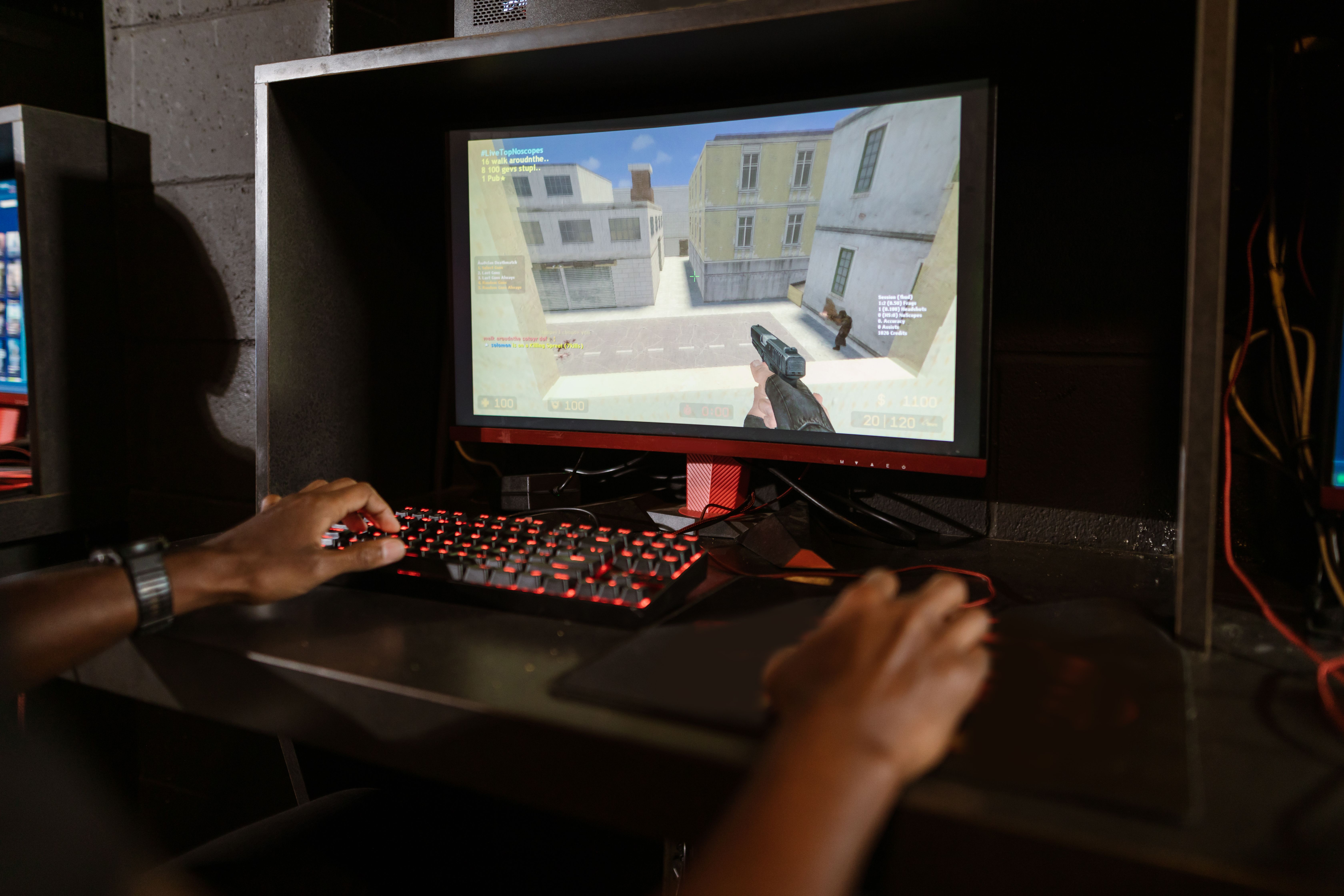 Gamer playing a shooter game on a high-performance PC setup with a mechanical keyboard and mouse